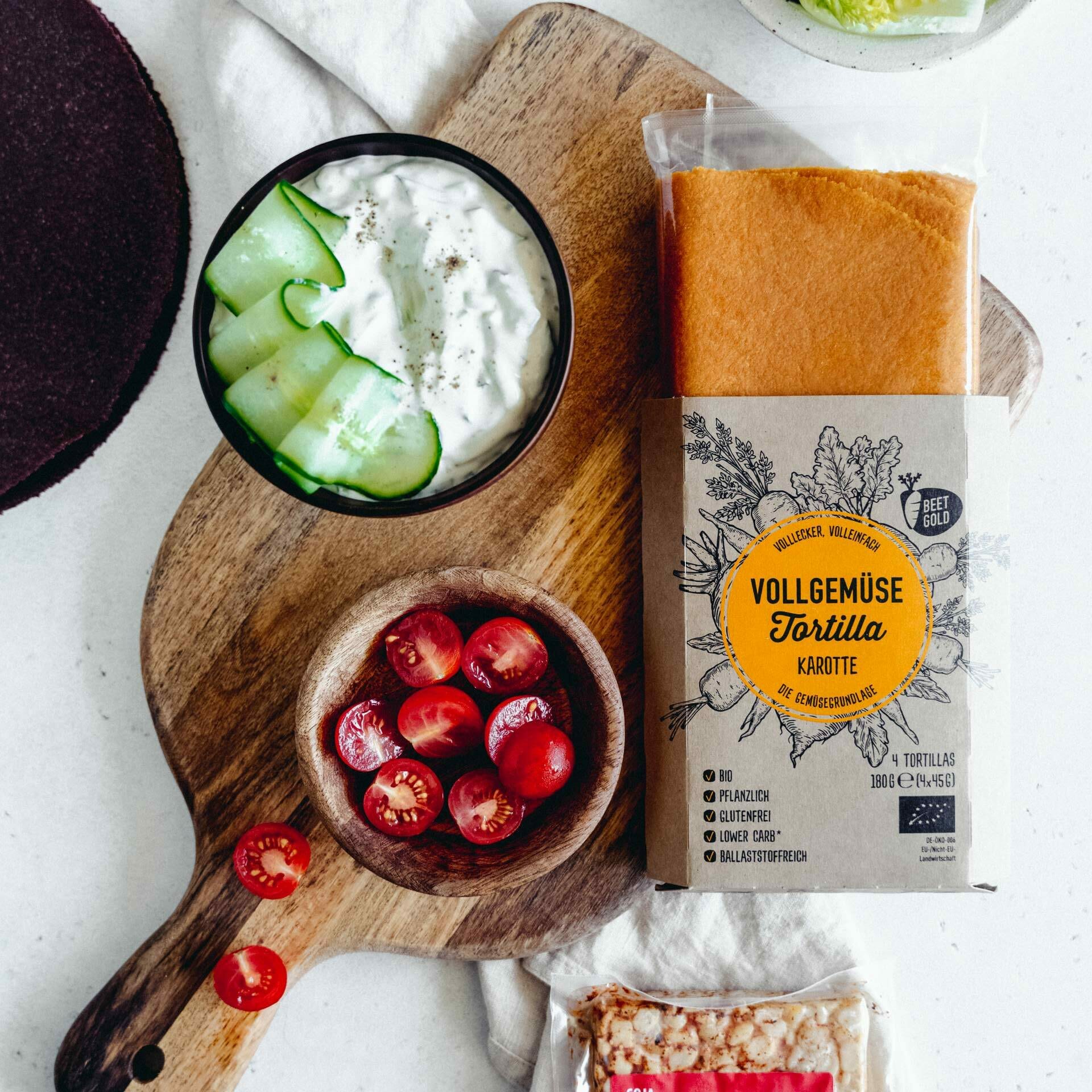 Zutaten für das Rezept: Karotten Tortilla in Verpackung, Cocktailtomaten, Tempeh und Tsatsiki