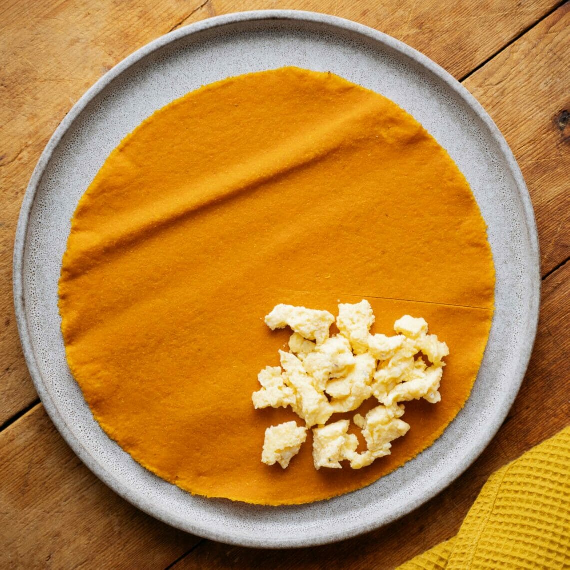 Karotten Tortilla ist zur Hälfte eingeschnitten und ein Viertel mit Rührei belegt