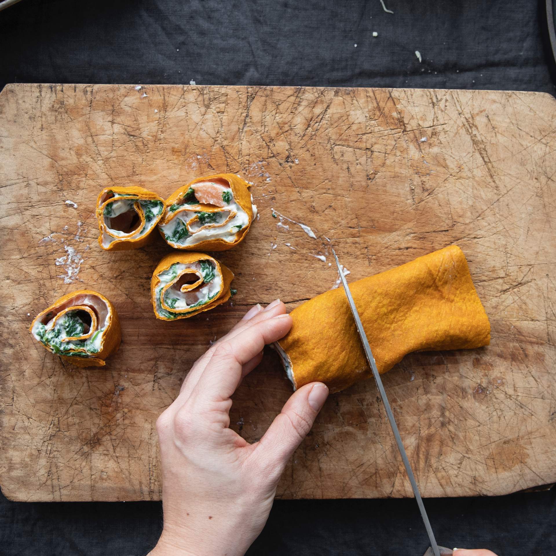 Gerollte Karotten Tortilla Wraps gefüllt mit Lachs, Spinat und Ziegenkäse wird in Stücke geschnitten