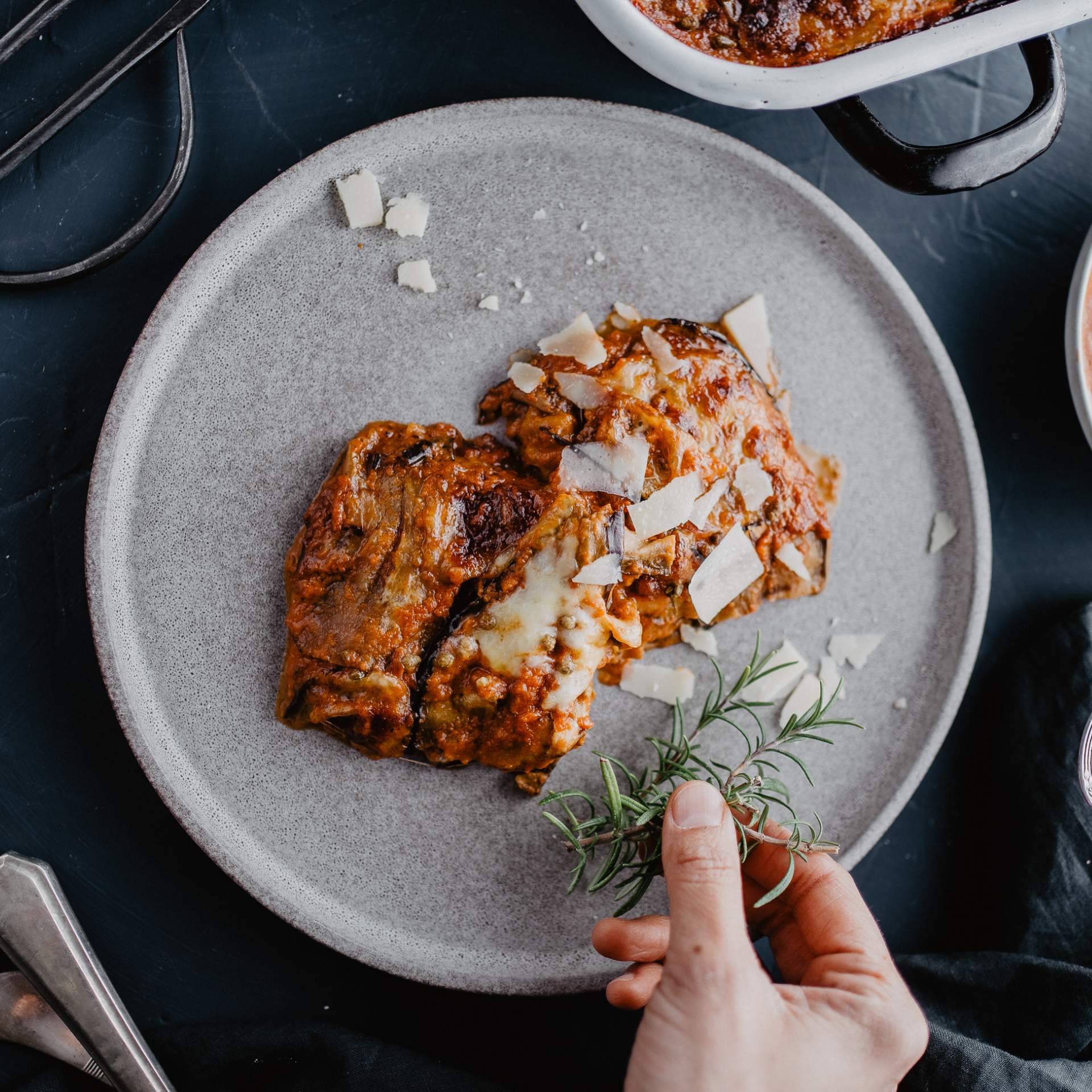 Parmigiana Stücke auf Teller mit Parmesan und Rosmarin