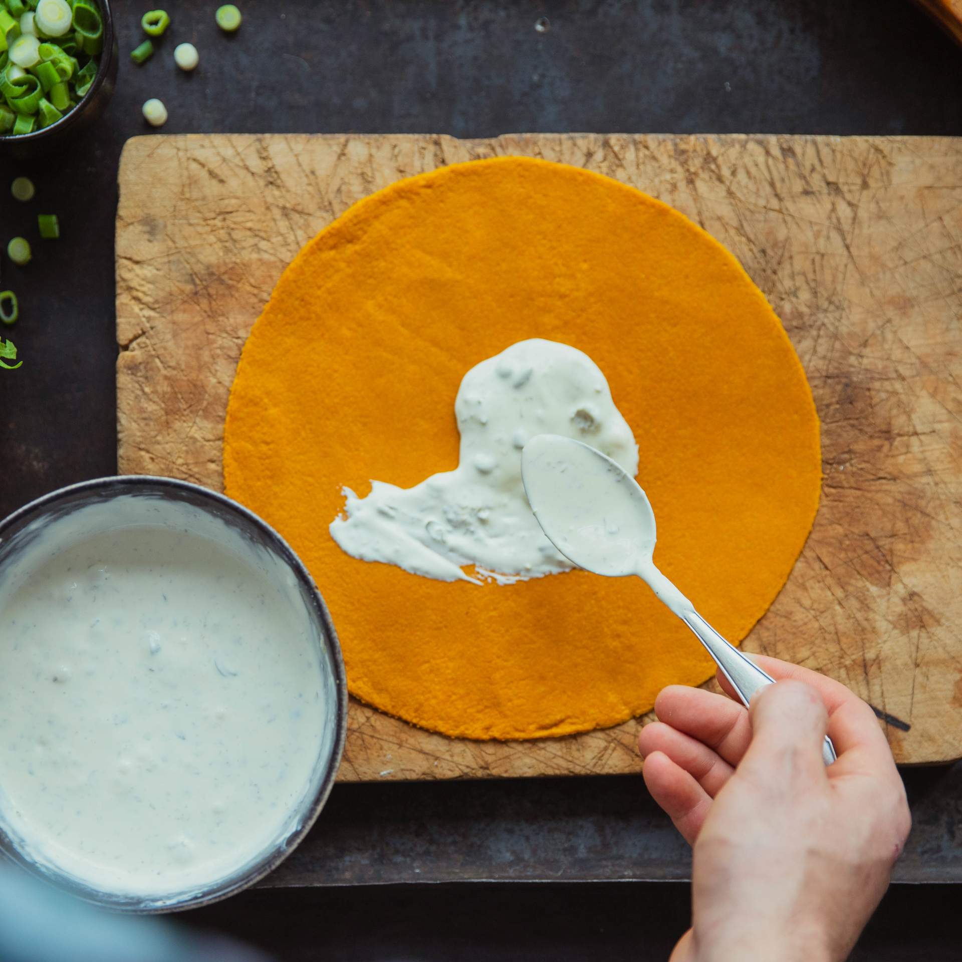 Kapern Creme wird auf Karotten Tortilla mit einem Löffel verteilt