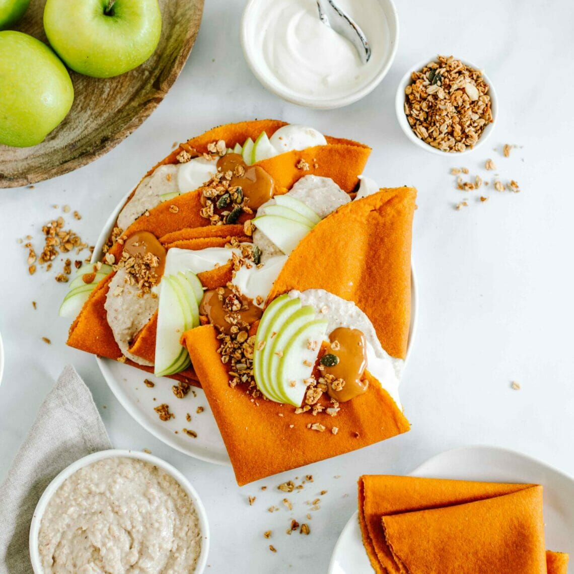 Karotten Tortilla als Pfannkuchen gefüllt mit Porridge, Äpfeln, Müsli und Nussmus