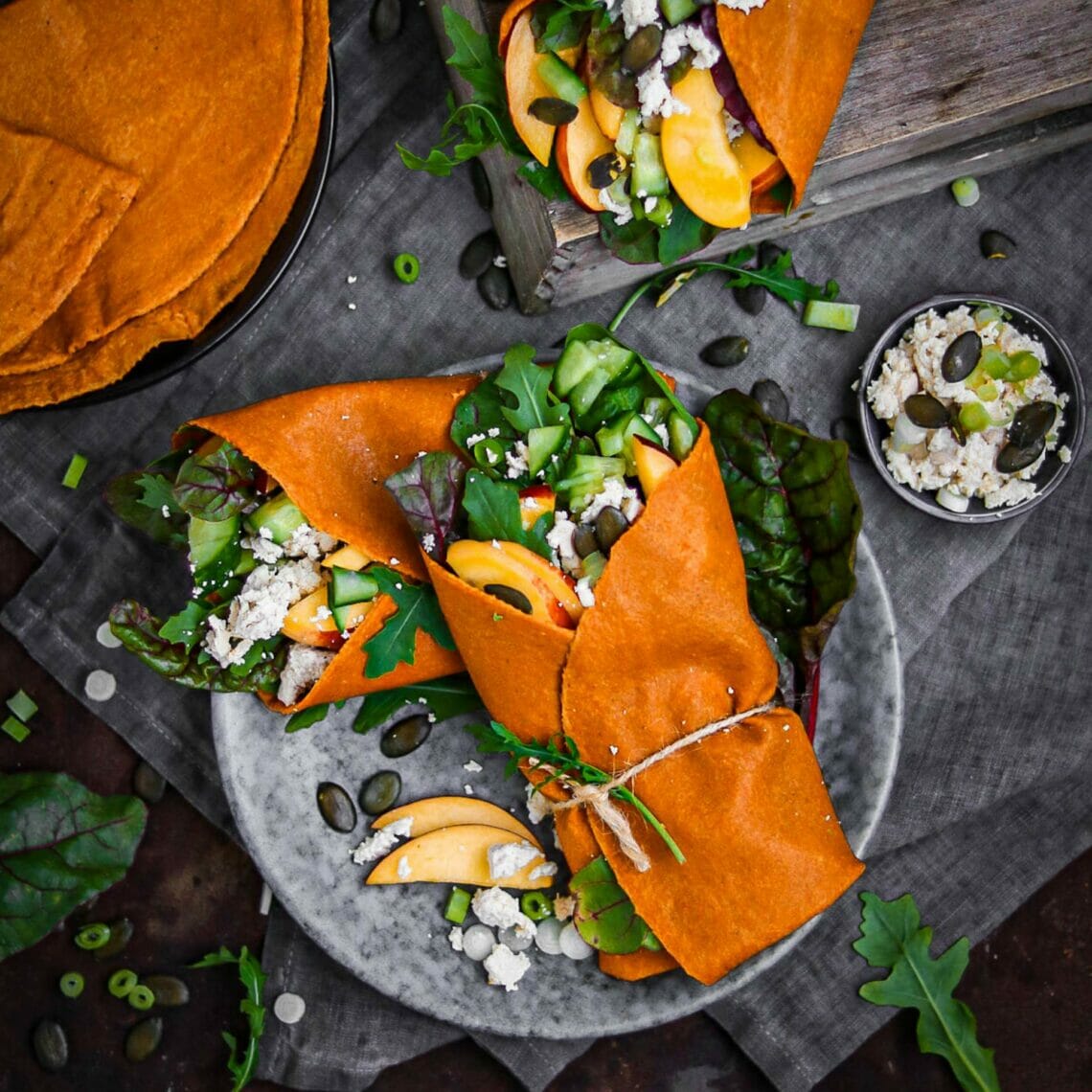 Gefüllte Tortilla Wraps mit Nektarinen, Buntem Salat und Kürbiskernen, zusammengebunden mit einer Schnur