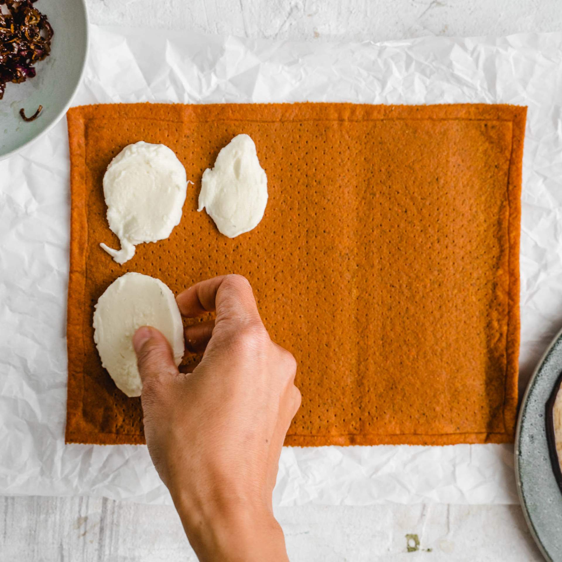 Mozzarella Scheiben werden auf den Gemüse Pizzaboden gelegt