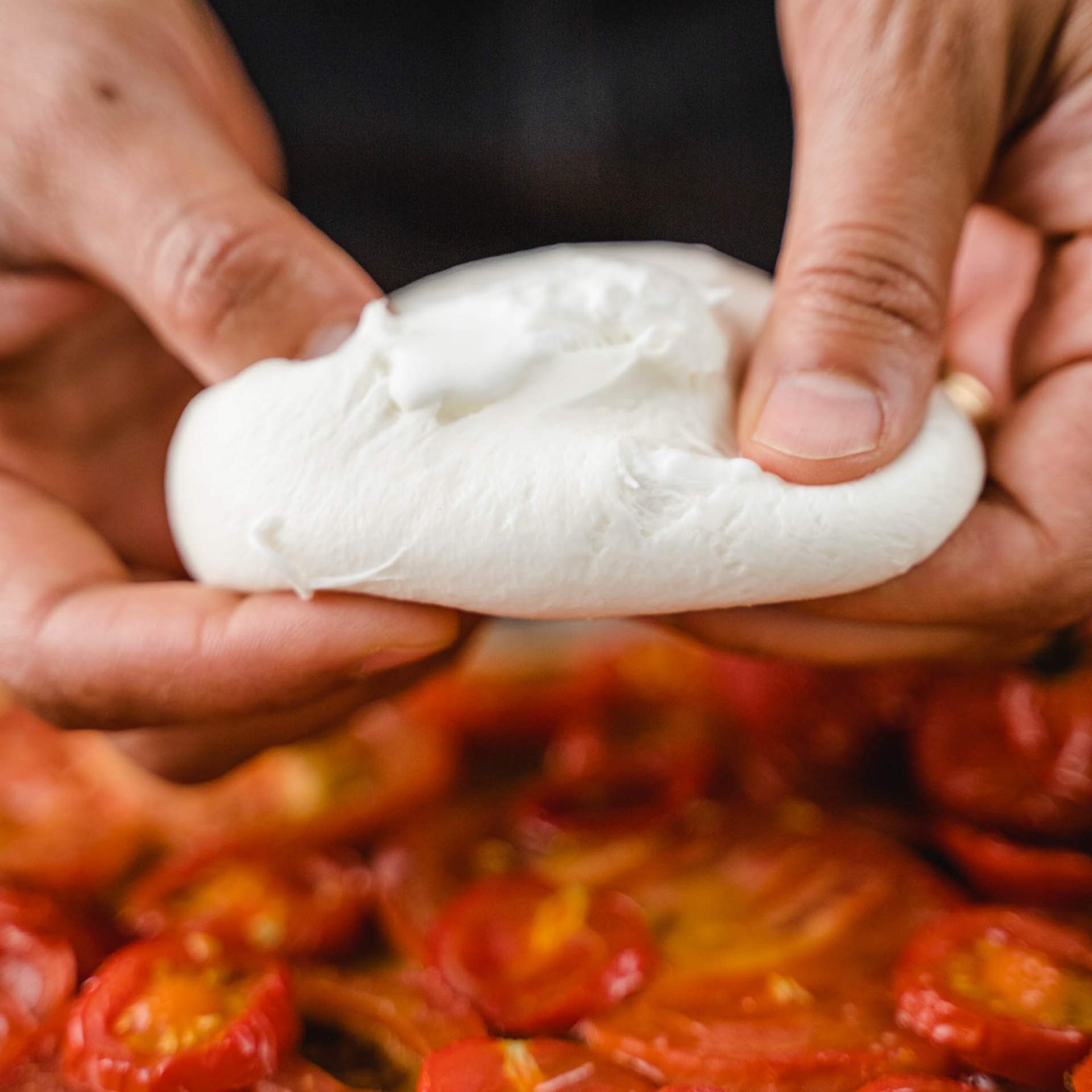 Burrata wird in Händen gehalten