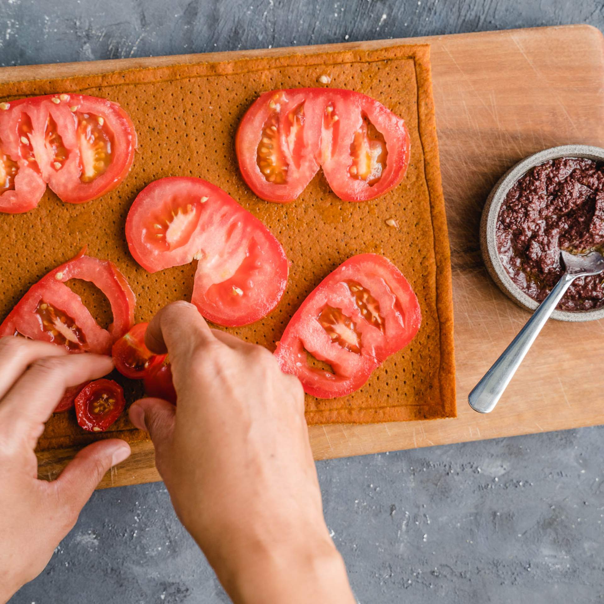 Cocktail Tomatenscheiben werden auf einen bereits mit großen Tomatenscheiben belegten Gemüse Pizzaboden gelegt