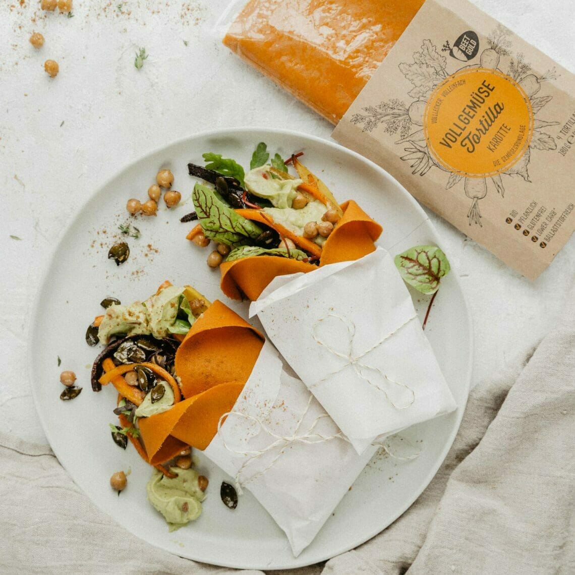 Karotten Tortilla Wraps gefüllt mit geröstetem Wurzelgemüse und Guacamole auf Wildkräutern