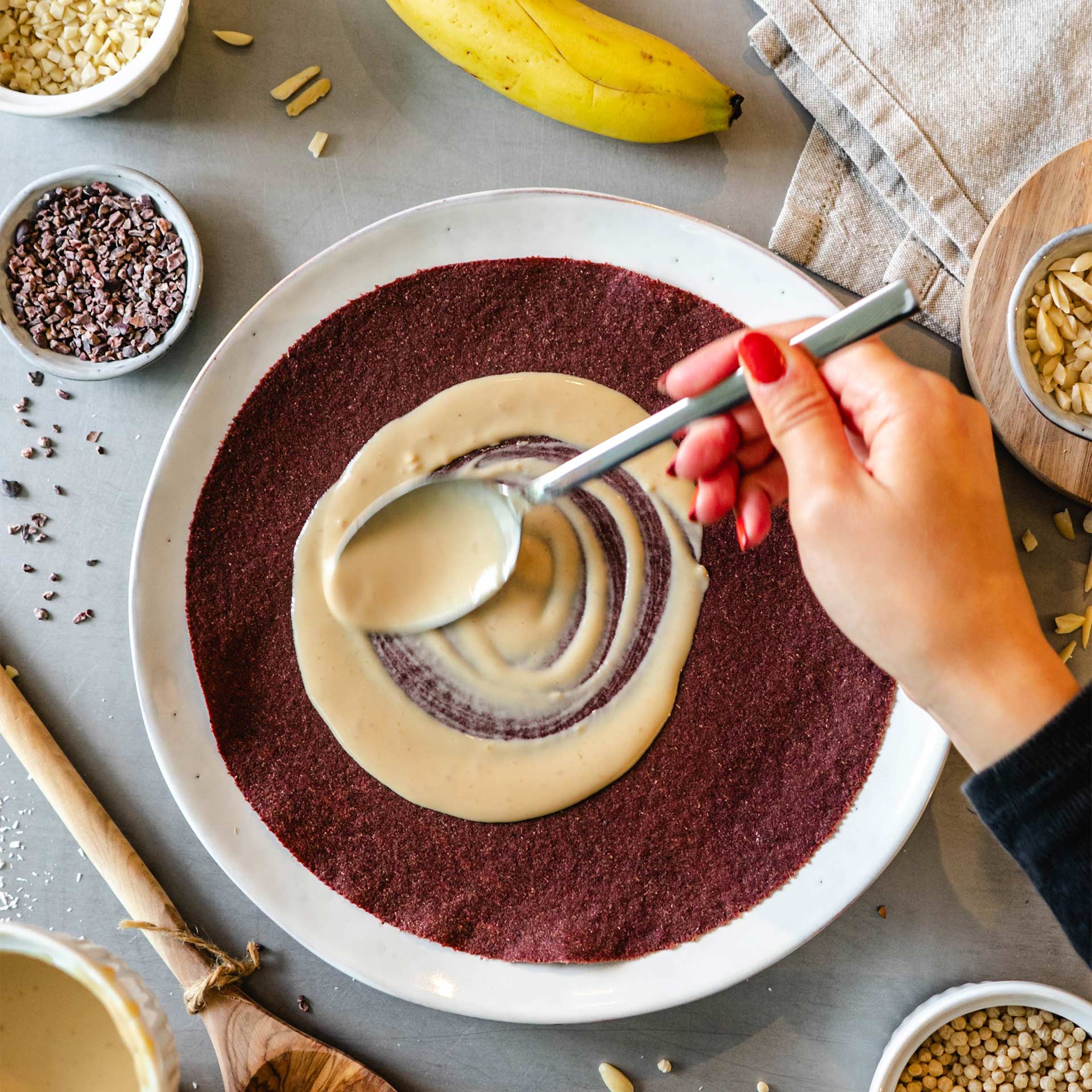 Nussmus wird mit einem Löffel auf Rote Beete Tortilla gegeben