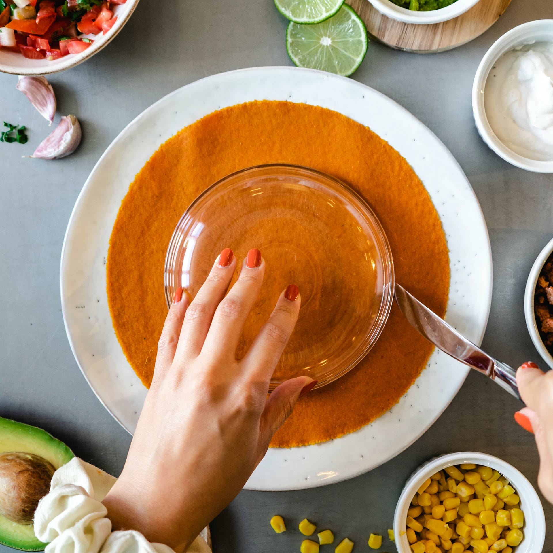 Karotten Tortilla Wrap wird mit Hilfe einer kleineren Schale zu einem kleineren Kreis geschnitten