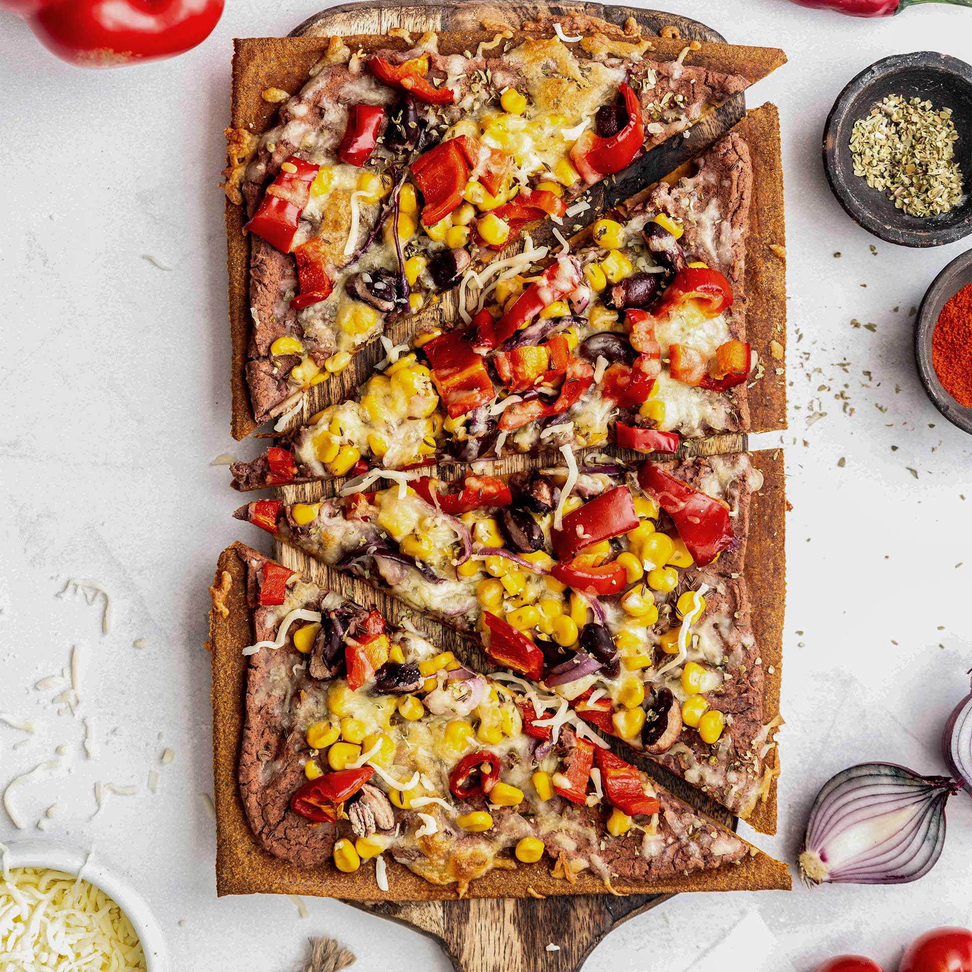 Geschnittener Beetgold Pizzaboden auf einem Holzbrett mit einem Mexikanisch Inspirierten Belag