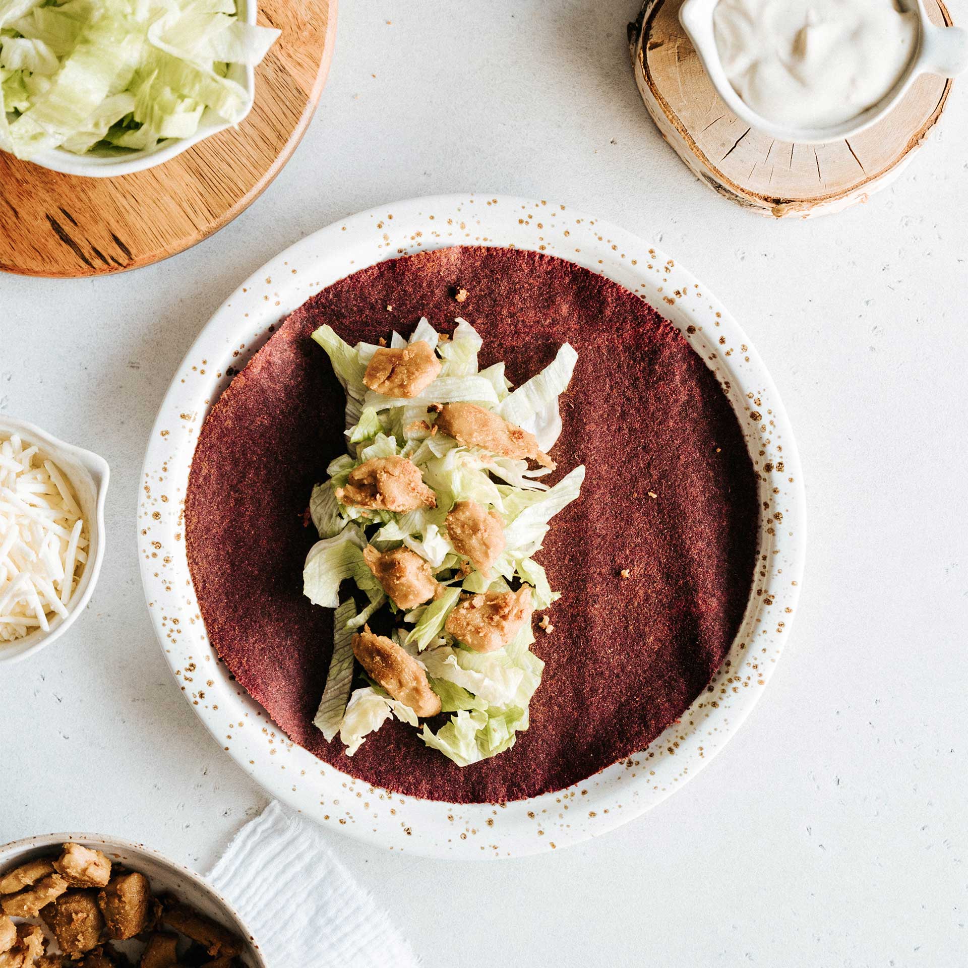 Rote Beete Tortilla Wrap belegt mit Salat und veganem Chicken