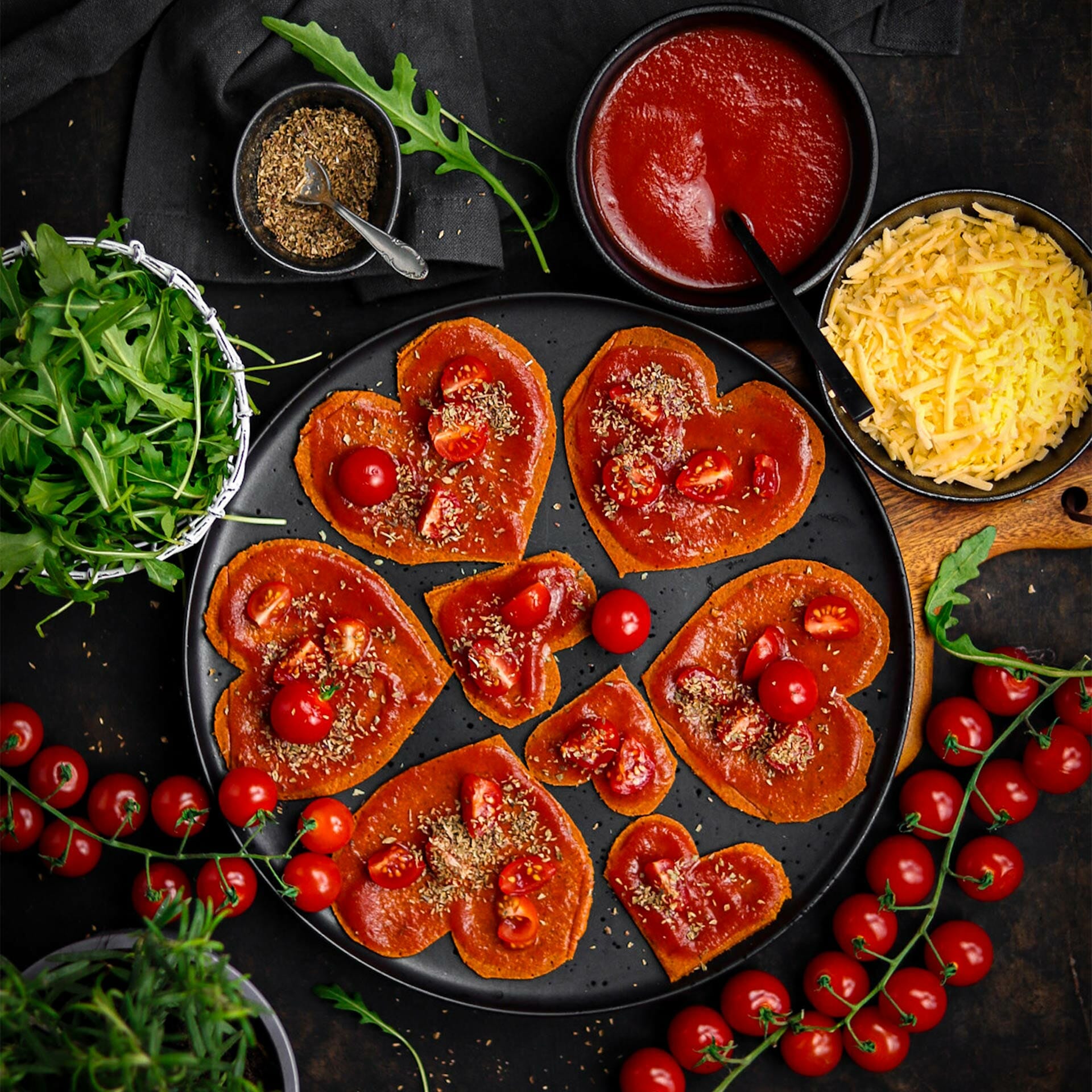 Herzen aus Pizzaboden mit Tomatensauce und Italienischen Kräutern, belegt mit Cocktailtomaten