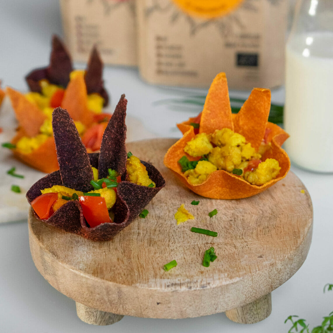 Rote Beete und Karotten Tortillas als Muffin Cups auf Holztablett gefüllt mir Rührei und Tomaten mit Tortilla Chips in Form von Hasenohren