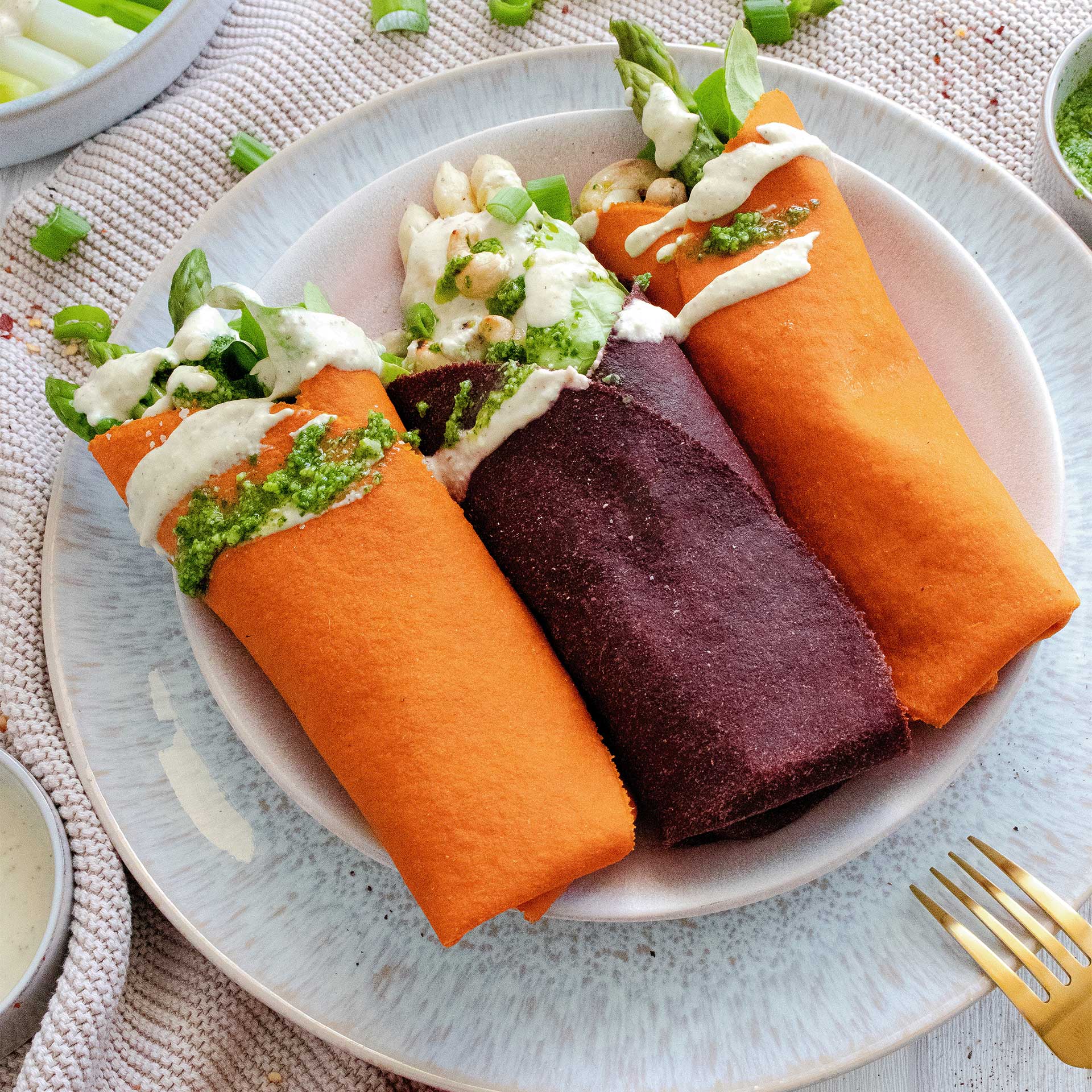 Karotten und Rote Beete Tortilla Wraps gefüllt mit Salat, Spargel, Cashewnüssen und getoppt mit Bärlauchpesto und Sauce Hollandaise